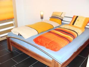 a bed with colorful pillows on top of it at Apartment Burn- Alte Strasse by Interhome in Adelboden
