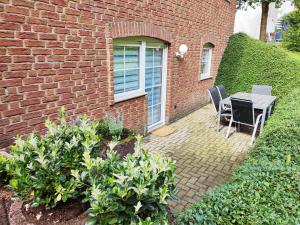 a patio with a table and chairs next to a brick building at Ferienwohnung Waldblick Teutoburger Wald in Oerlinghausen