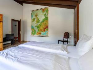 a bedroom with a large white bed with a map on the wall at Apartment Près du Bahnhof by Interhome in Engelberg