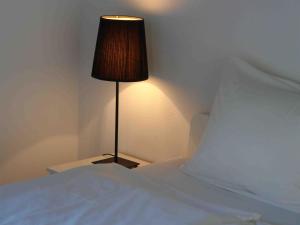 a bed with a lamp next to a white bed at Apartment Près du Bahnhof by Interhome in Engelberg