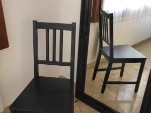 a black chair in front of a mirror at Apartment Près du Bahnhof by Interhome in Engelberg