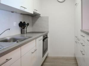 a kitchen with white cabinets and a sink at Apartment Derborence 28 by Interhome in Nendaz