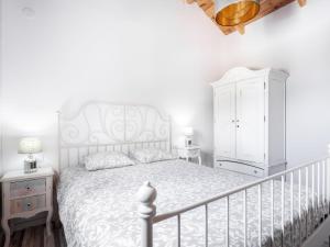 a bedroom with a white bed and a white cabinet at Holiday Home Jorge by Interhome in Zamorano
