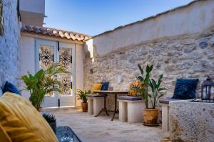 a patio with a table and a stone wall at Town House Rosario in Stari Grad