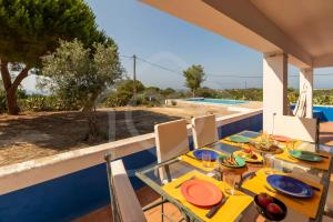 a table with plates of food on top of a house at Villas2go2 Praia da Marinha in Lagoa