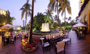 a restaurant with tables and chairs and a fountain at The Leela Mumbai in Mumbai
