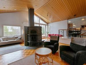 a living room with a fireplace and a table and chairs at Holiday Home Polkurinne by Interhome in Saarijärvi