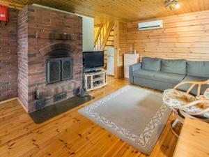 uma sala de estar com um sofá e uma lareira em Holiday Home Villa koivumäki by Interhome em Kankaanpää