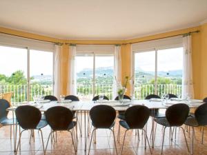 comedor con mesa, sillas y ventanas en Villa Florencia by Interhome, en Calpe