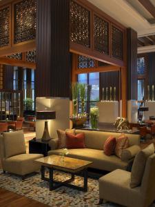 
a living room filled with furniture and a large window at The Leela Mumbai in Mumbai
