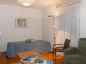 sypialnia z łóżkiem, krzesłem i stołem w obiekcie Apartment REX by Interhome w mieście Muralto