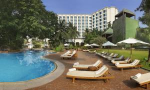 un hôtel avec des chaises longues et une piscine dans l'établissement The Leela Mumbai, à Mumbai