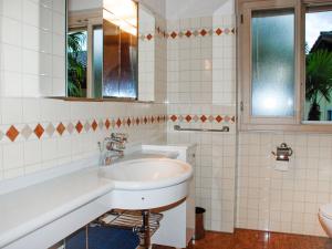 W łazience znajduje się umywalka i lustro. w obiekcie Apartment REX by Interhome w mieście Muralto