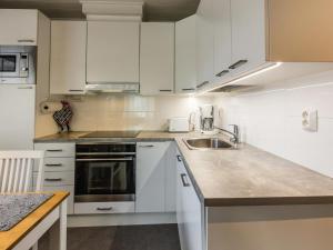 a kitchen with white cabinets and a sink at Holiday Home Taruilevi 8 h2 by Interhome in Sirkka