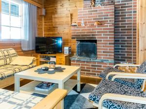 a living room with a brick fireplace and a table at Holiday Home Levilla by Interhome in Sirkka