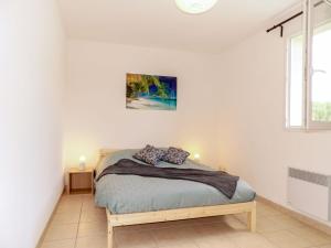 a bedroom with a bed in a white room at Apartment Les Jardins de l'Océan by Interhome in Bias