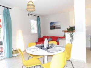 a dining room with a white table and yellow chairs at Apartment Les Jardins de l'Océan by Interhome in Bias +27 photos