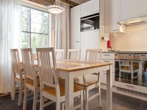 a kitchen with a wooden table and chairs at Holiday Home Taruilevi 10 j2 by Interhome in Sirkka