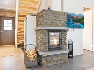 a stone fireplace in a living room with a tv at Holiday Home Taruilevi 10 j2 by Interhome in Sirkka