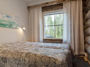 a bedroom with a bed in front of a window at Holiday Home Taruilevi 10 j2 by Interhome in Sirkka
