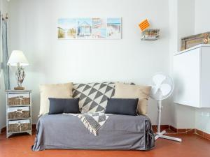 a bed in a white room with a fan at Apartment Les Cabestans 1-2-3-4 by Interhome in Le Barcarès