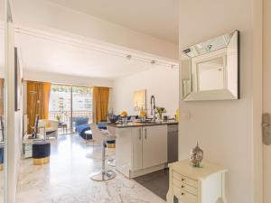 Il dispose d'une cuisine et d'un salon avec un lavabo et un miroir. dans l'établissement Apartment Presqu'Ile by Interhome, à Cannes