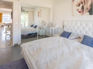 - une chambre avec un grand lit et un miroir dans l'établissement Apartment Presqu'Ile by Interhome, à Cannes