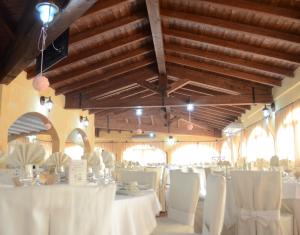 a dining room with white tables and white chairs at Hotel Giardino Corte Rubja in Iglesias