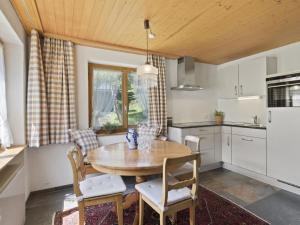 a kitchen with a wooden table and chairs at Apartment Riedblick by Interhome in Churwalden