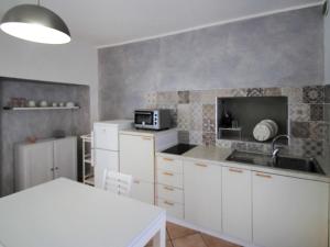 a kitchen with white cabinets and a microwave at Apartment White by Interhome in Germignaga +21 photos