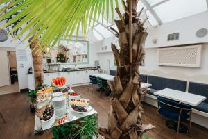 una habitación con una mesa con comida y una palmera en Hotel Jan en Cracovia