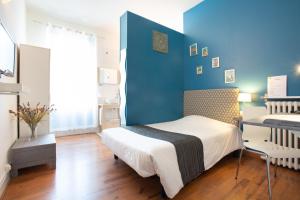 Rúm í herbergi á Logis Hotel L'Occitan 2 étoiles