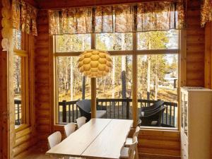 a dining room with a table and a large window at Holiday Home Hirsikoto by Interhome in Saariselka