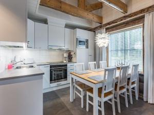 a kitchen with a table and chairs and a kitchen with white cabinets at Holiday Home Taruilevi 8 h3 by Interhome in Levi