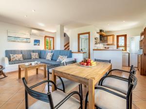 ein Wohnzimmer mit einem blauen Sofa und einem Tisch und Stühlen in der Unterkunft Holiday Home Ran de Mar 35 by Interhome in Colònia de Sant Pere