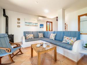 ein Wohnzimmer mit einem blauen Sofa und einem Tisch in der Unterkunft Holiday Home Ran de Mar 35 by Interhome in Colònia de Sant Pere