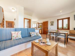 ein Wohnzimmer mit einem blauen Sofa und einem Tisch in der Unterkunft Holiday Home Ran de Mar 35 by Interhome in Colònia de Sant Pere + 18 Fotos