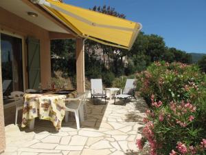 un patio con mesa, sillas y sombrilla amarilla en Holiday Home Marie-Julie by Interhome, en Le Muy