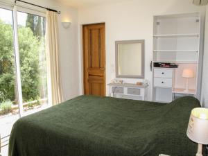 1 dormitorio con cama verde y espejo en Holiday Home Marie-Julie by Interhome, en Le Muy