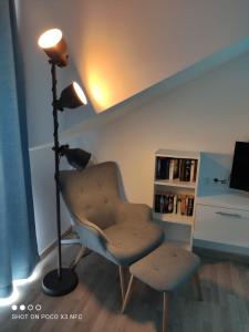 a lamp and a chair in a living room at 5D Apartament przy Plaży in Grzybowo