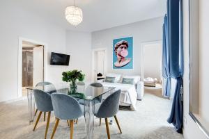 a living room with a glass table and blue chairs at Trevi Fountain - NEW! - Your Italian Holidays in Rome