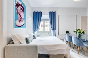 a bedroom with a white bed and blue curtains at Trevi Fountain - NEW! - Your Italian Holidays in Rome