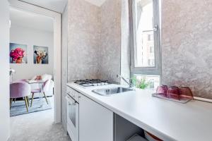 a white kitchen with a sink and a window at Trevi Fountain - NEW! - Your Italian Holidays in Rome