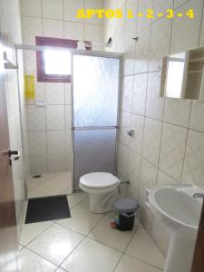 a bathroom with a shower and a toilet and a sink at APEVO ILHA in Ilha Comprida
