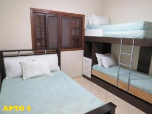 Pokój z 2 łóżkami piętrowymi i oknem w obiekcie APEVO ILHA w mieście Ilha Comprida