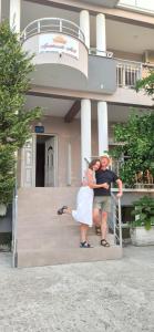 Ein Mann und eine Frau stehen vor einem Gebäude in der Unterkunft Apartment's Meti in Ulcinj