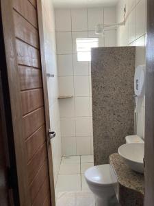 a bathroom with a toilet and a sink at Pousada do Rancho in Barreirinhas