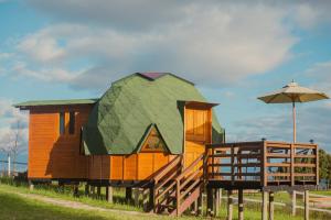 una pequeña casa con techo verde y sombrilla en Reserva Campestre LA CABAÑA GLAMPING, en Duitama