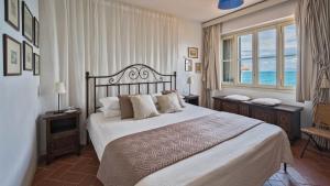 a bedroom with a large bed and a large window at Villetta in Monte Argentario