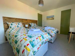 a bedroom with two beds and a wooden headboard at Spacious 2 Bedroom Home in Picturesque Cullen in Cullen